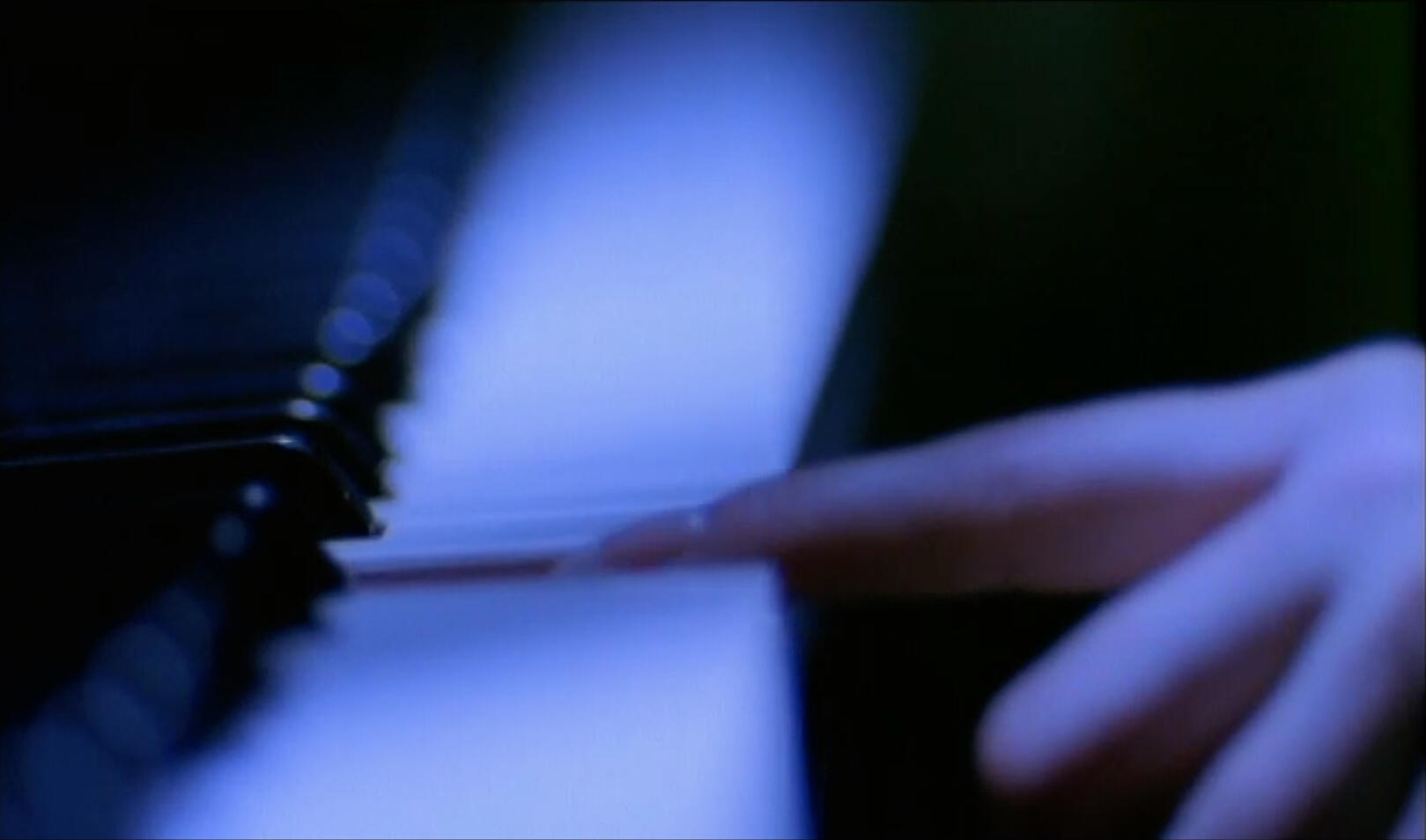 Extreme short depth of field image by Scott L. Dale Handheld lens in front of camera, extreme short depth of field - Image finger striking piano key in cool light by Scott L. Dale.